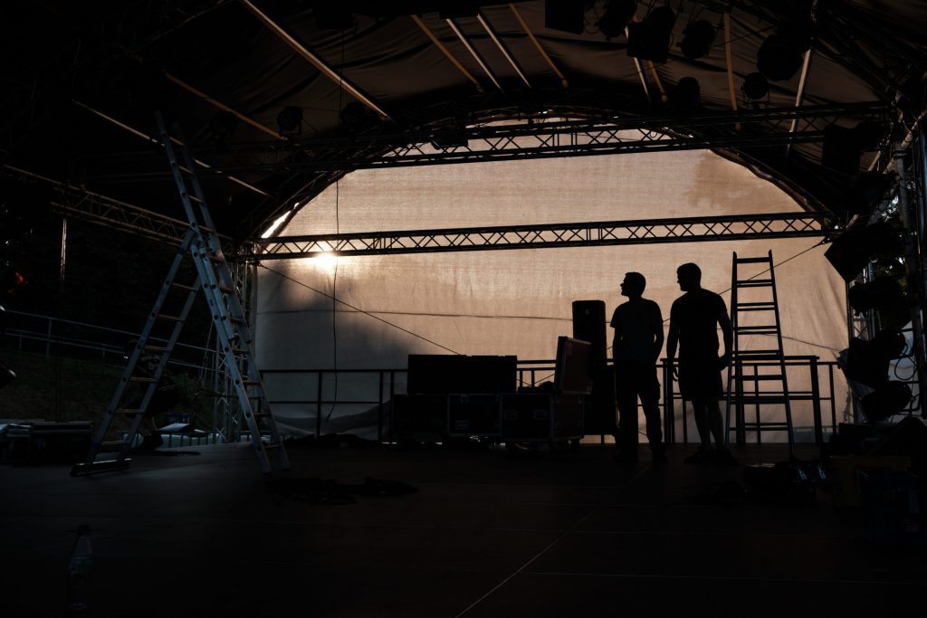 Zwei Silhouetten auf der Festivalbühne beim Aufbau des Umsonst und Draußen 2022